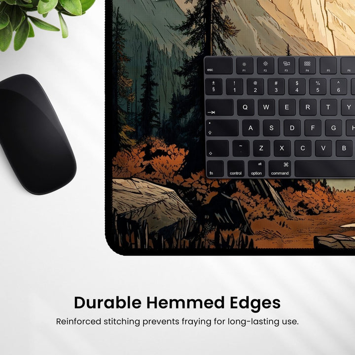 Home Decor - The Mountain Desk Mat – Large Nature Desk Mat for Gaming & Office features a scenic forest and valley design with trees and mountains, partially covered by a black keyboard. A black computer mouse sits on the left side. Text at the bottom reads "Durable Hemmed Edges: Reinforced stitching prevents fraying for long - lasting use. - Kaladyn Designs