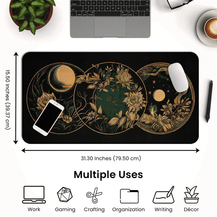 A desk setup featuring the Art Nouveau Celestial Moon Desk Mat – Witch Aesthetic Gaming Mouse Pad. This black rectangular mouse pad showcases a mystical celestial design in golden hues and measures 31.30 inches by 15.50 inches, providing ample space for an open laptop and smartphone. Icons below highlight its versatility for work, gaming, crafting, organizing, writing, and décor.