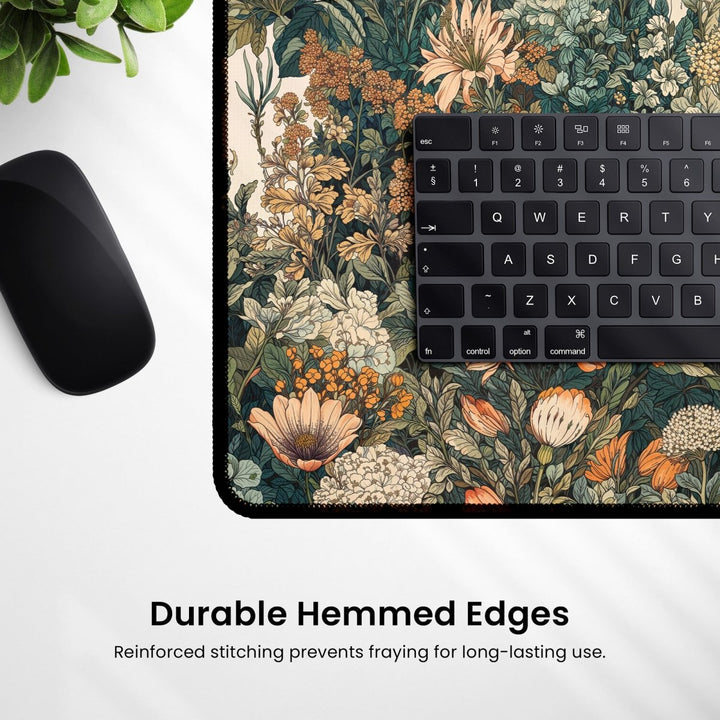 Home Decor - The Botanical Desk Mat, a vintage floral large mouse pad designed for office and gaming, adds charm to your workspace with its elegant pattern. Featuring a black keyboard partially visible on top and a black wireless mouse resting on the left, this accessory boasts "Durable Hemmed Edges" alongside reinforced stitching for long - lasting use. - Kaladyn Designs