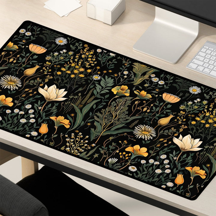 Home Decor - A desk setup featuring a computer monitor, keyboard, and mouse on a light wood surface. The elegant workspace is enhanced by the Botanical Floral Desk Mat – Large Nature - Inspired Mousepad for Office & Gaming, showcasing a vibrant floral design with yellow, white, and orange flowers amid green foliage on a black background. - Kaladyn Designs