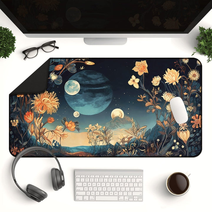 Home Decor - A desktop setup featuring the large Celestial Floral Desk Mat – a whimsical, moon - themed mouse pad adorned with stars and flowers. The desk includes everything you need: a keyboard, mouse, monitor, eyeglasses, headphones, a small plant, and a cup of coffee. - Kaladyn Designs