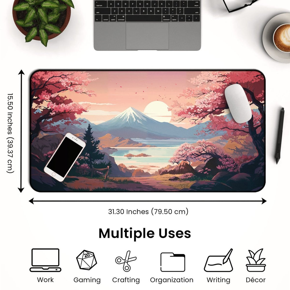 Home Decor - A desk arrangement includes the Cherry Blossom Anime Desk Mat, showcasing a scenic landscape with mountains, a lake, and sakura blooms. Surrounding the Sakura Desk Pad for Aesthetic Desks are a laptop, smartphone, and cup of coffee. Below the setup, text emphasizes its versatility for work, gaming, crafting, and beyond. - Kaladyn Designs