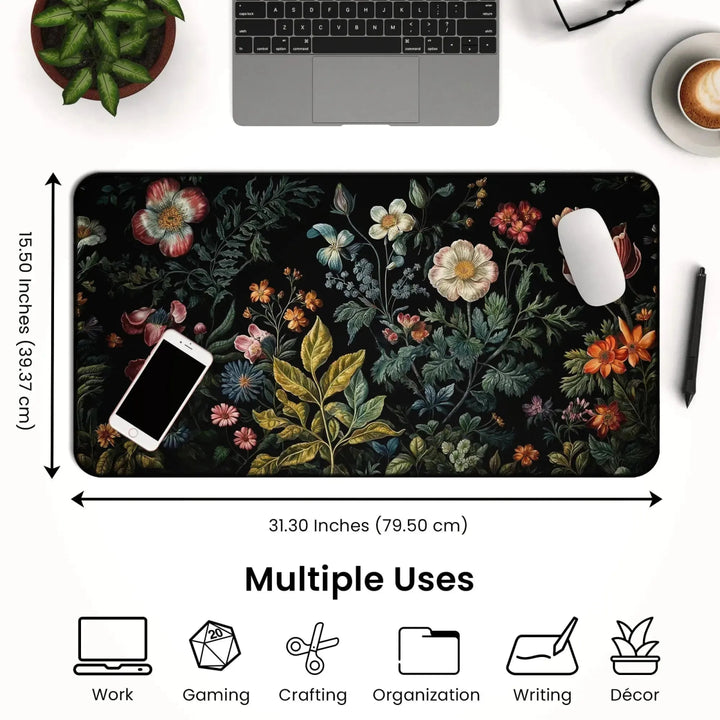 The Dark Cottagecore Desk Mat – Vintage Floral Non-Slip Mouse Pad for Gaming & Office is placed on a desk with a laptop, phone, mouse, and houseplant. Its non-slip surface ensures stability across its dimensions of 31.30 inches (79.50 cm) by 15.50 inches (39.37 cm). Icons below highlight its use for work, gaming, crafting, organization, writing, and decor.