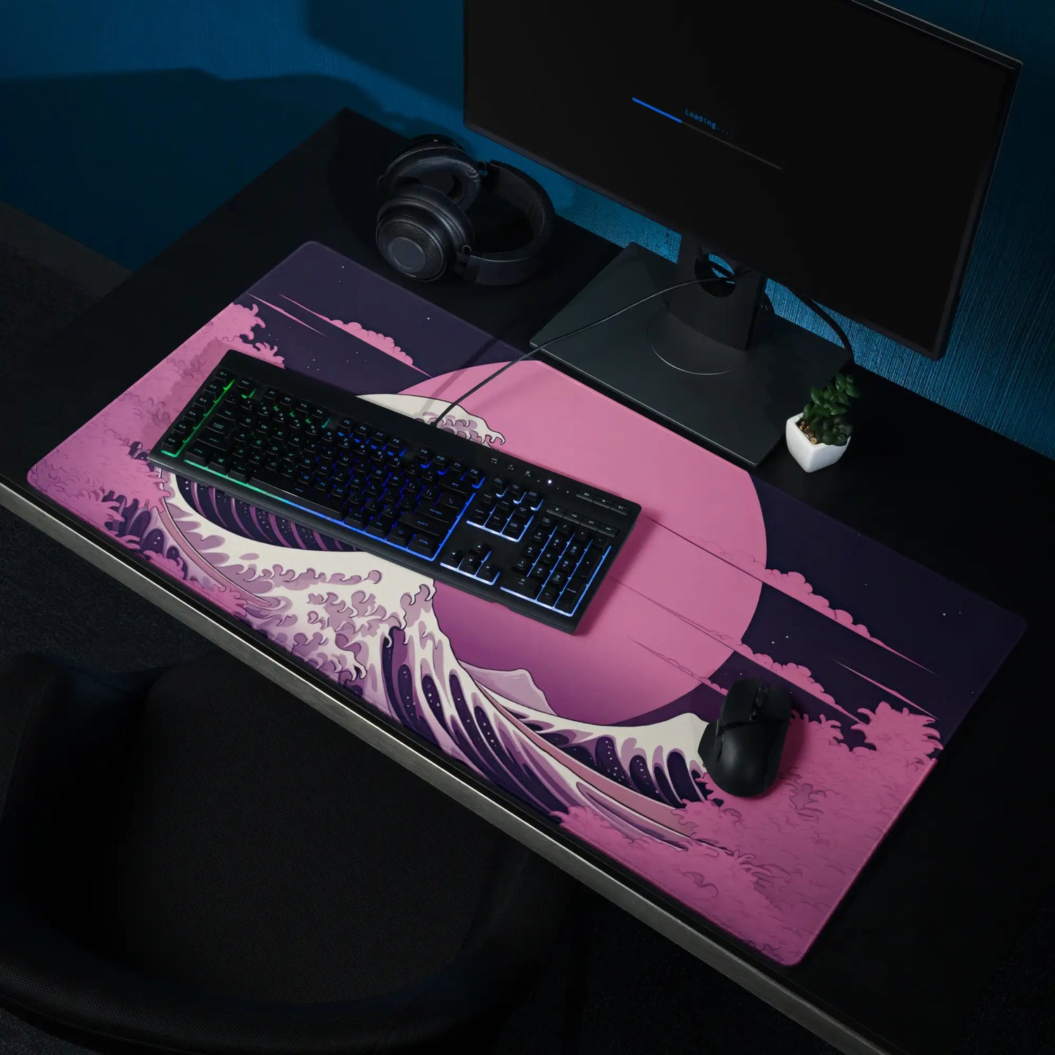 A large gaming desk mat with a pink wave on it.