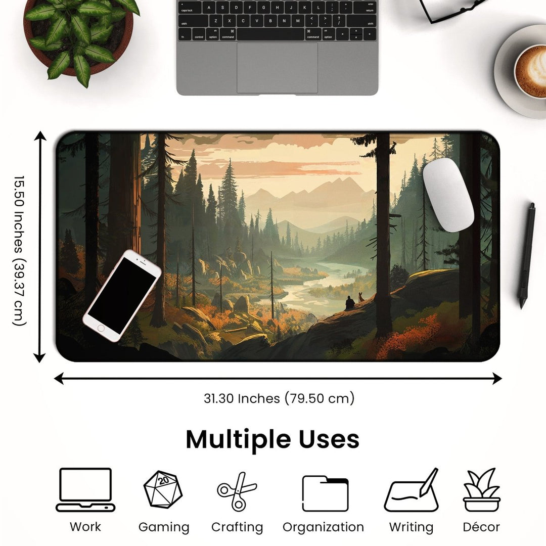 Home Decor - The Mountain Desk Mat – Large Nature Mousepad for Gaming & Office is showcased, illustrating a scenic forest landscape with mountains and a river. It is placed on a desk along with a laptop, cup of coffee, pen, and note cards. Measuring 31.30 x 15.50 inches (79.50 x 39.37 cm), it features icons indicating its various uses: work, gaming accessory, crafting, organization, writing, and décor. - Kaladyn Designs
